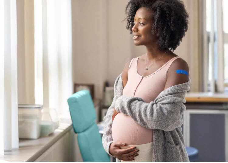 Actor portrayal of a pregnant woman feeling her belly